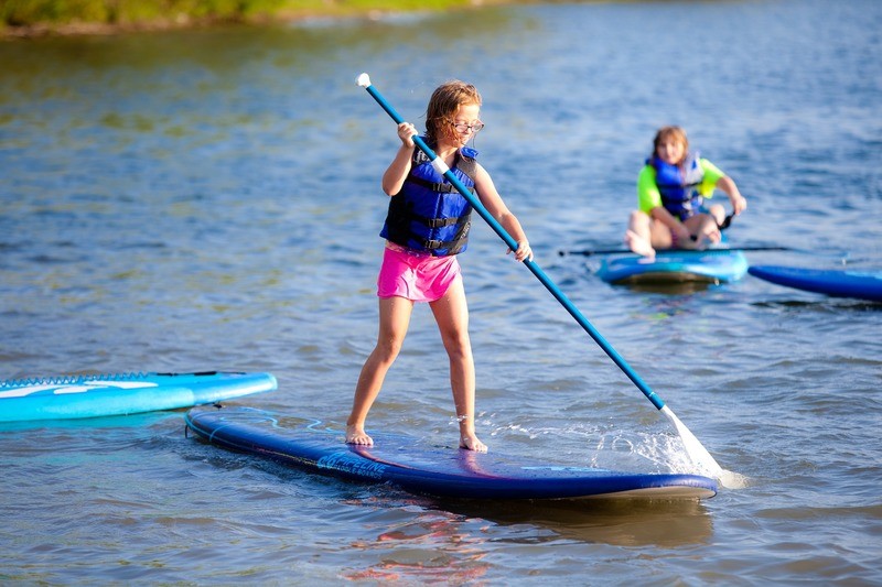 Kids paddle boarding on a lake