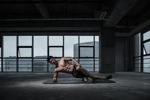 man using a foam roller to roll out his hip
