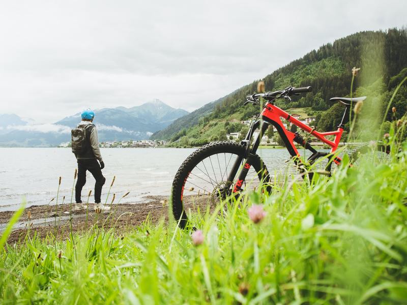 person with bike looking at lake