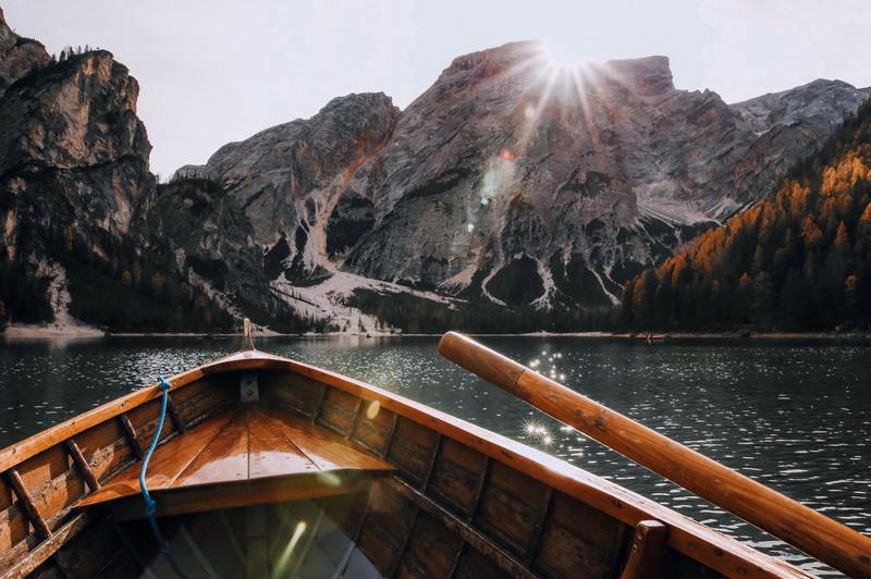 brown canoe on body of water facing a mountain