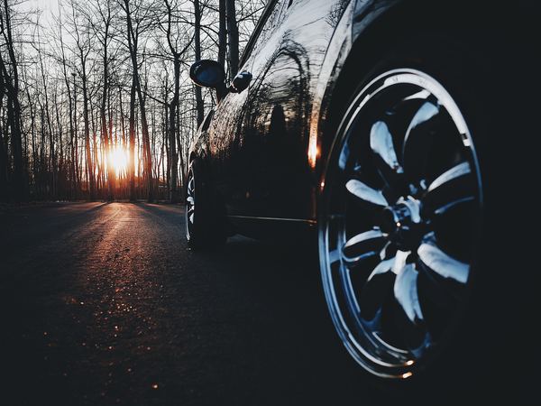 Expensive car on the road at sunset