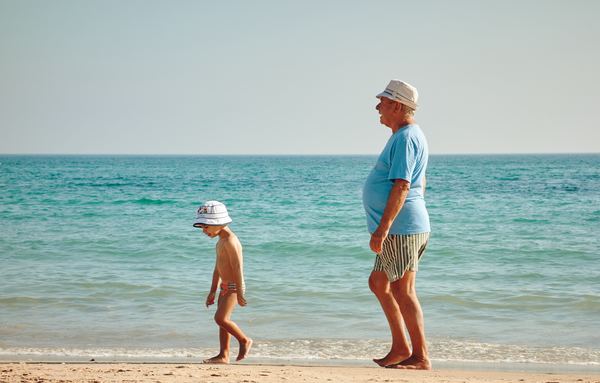 Elderly man and child on beach