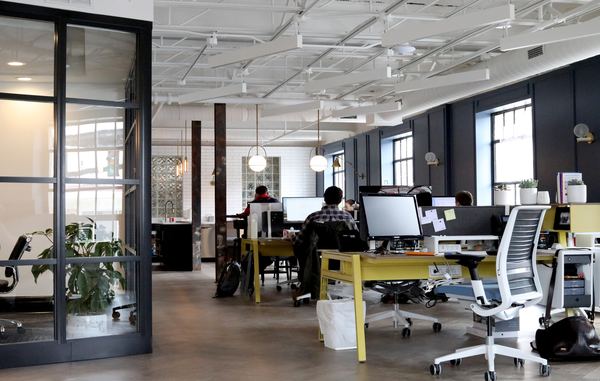 A large, open-concept office space with several computers and large windows